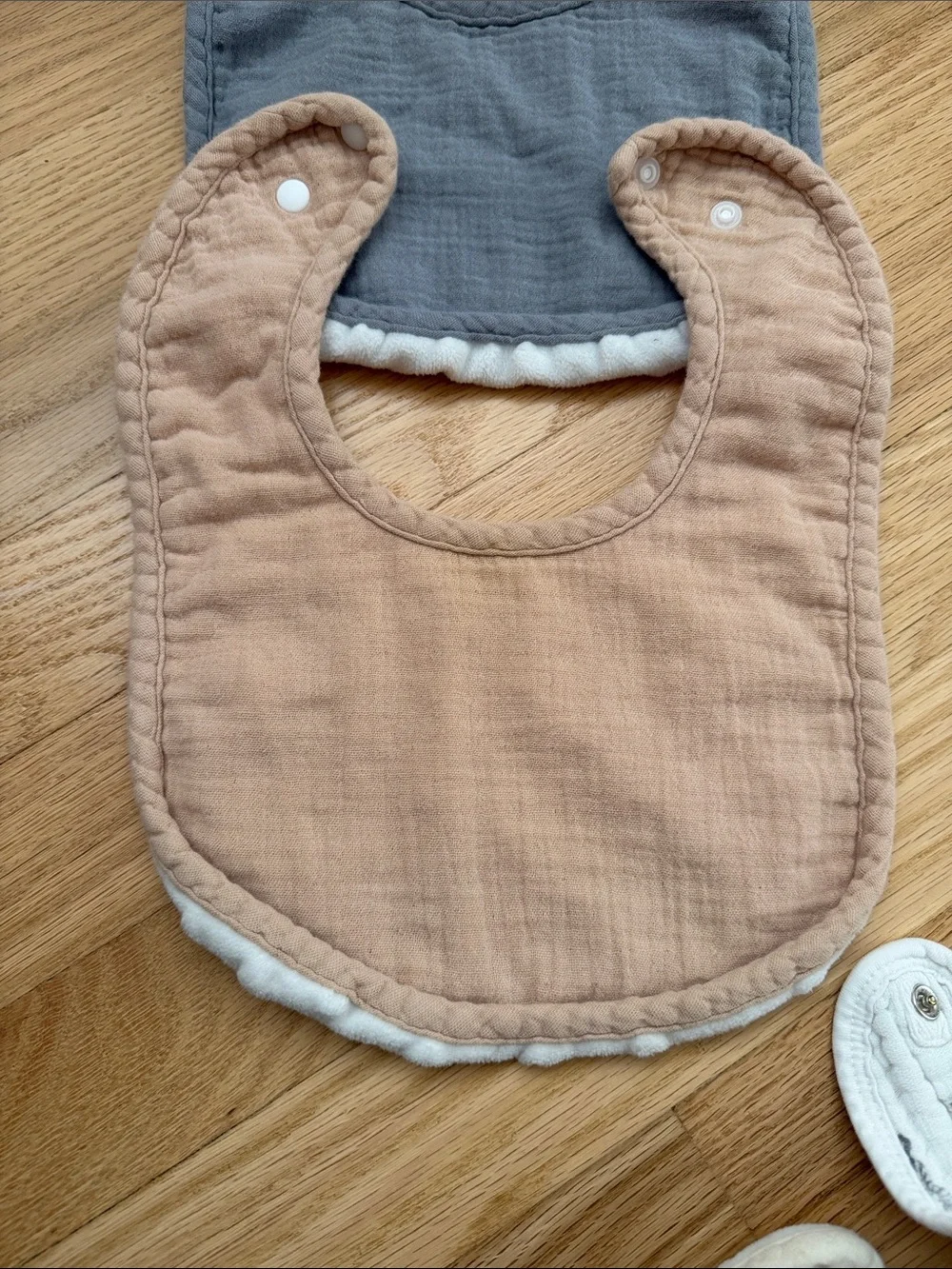 Bundle of muslin baby bibs in earthy colors